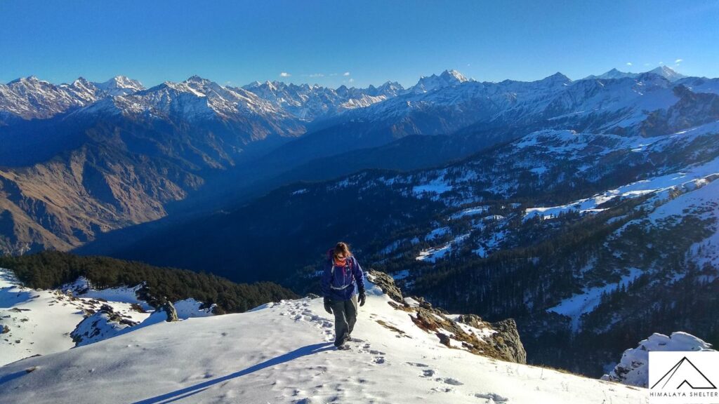 trekker ascending on the kedarkantha trek and view of surroundings